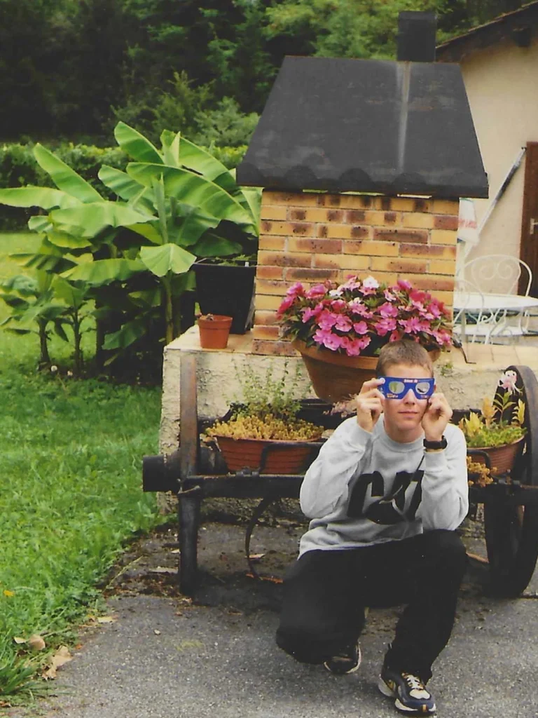 Arnaud Lamy enfant en août 1999 dans le jardin familial portant les lunettes éclipse du numéro Sciences et Vie